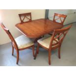 A modern extending dining table and 4 chairs with cream coloured upholstery.