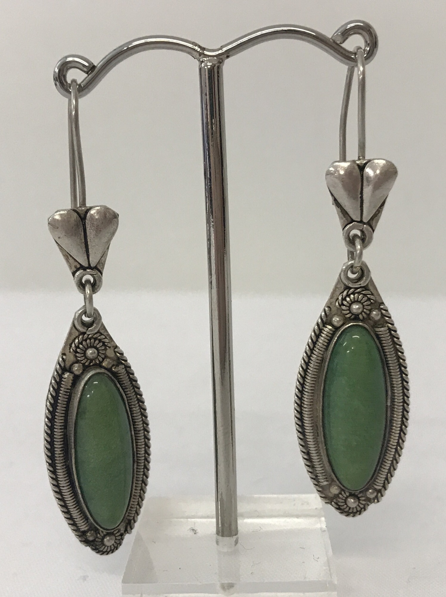 A pair of drop earrings set with natural green stones by Ozgen.