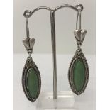 A pair of drop earrings set with natural green stones by Ozgen.