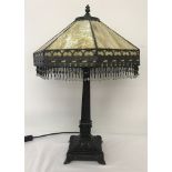 A Tiffany style table lamp with mottled cream/brown glass shade with beaded fringe decoration.