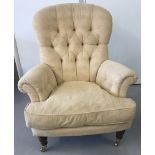 An armchair in cream upholstery of classic design.