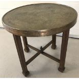 An eastern style brass topped side table with 4 legged folding base.