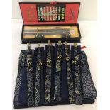 A blue and gold fabric napkin and chopsticks table set together with a boxed chopsticks & stand set.