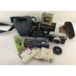 A collection of 4 vintage cameras and assorted accessories.