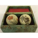 A boxed pair of natural stone stress balls with flower decoration.