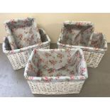 A collection of modern storage baskets, in white with floral fabric inserts.