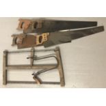 A quantity of vintage wooden handled saws to include 4 hand saws and a bow saw.