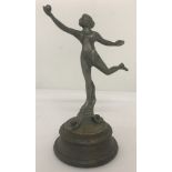 An Art Deco Style car mascot of a naked woman balancing, holding a ball in one hand.