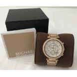 A boxed Michael Kors ladies rose gold tone chronograph wrist watch.