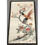 A framed and glazed embroidered silk panel of oriental pheasants in a tree.