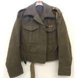 A vintage wool cropped battledress jacket complete with badges and insignia.