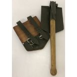A leather cased folding trenching shovel/pick with wooden handle, dated 1966.