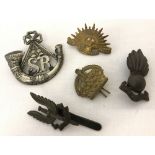 A collection of 5 assorted cap badges.