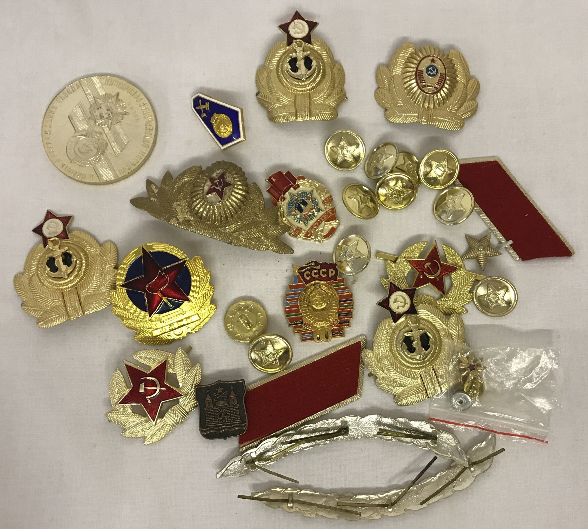 A bag of Cold War style metal Soviet badges and insignia.