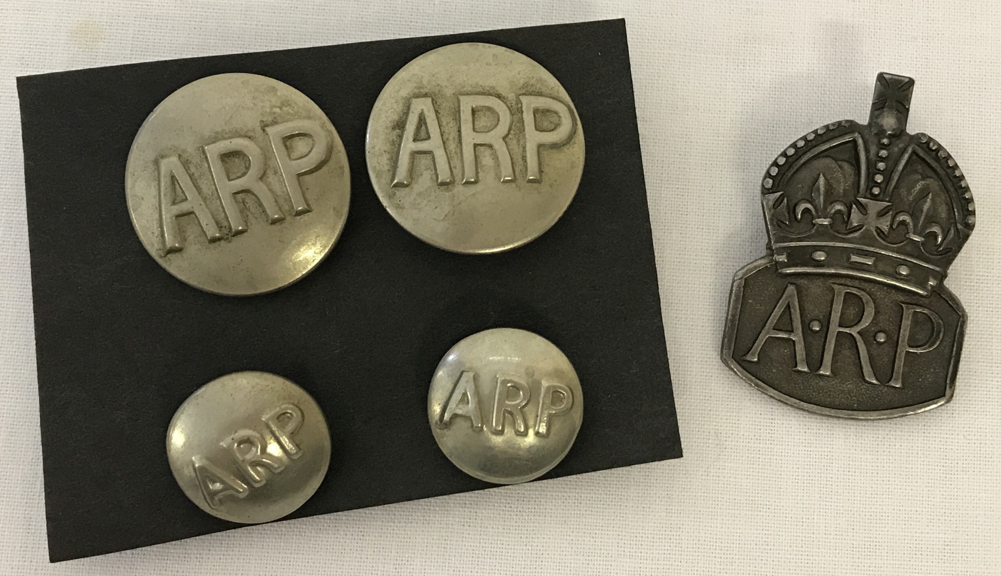 A silver ARP lapel badge together with 4 ARP buttons.