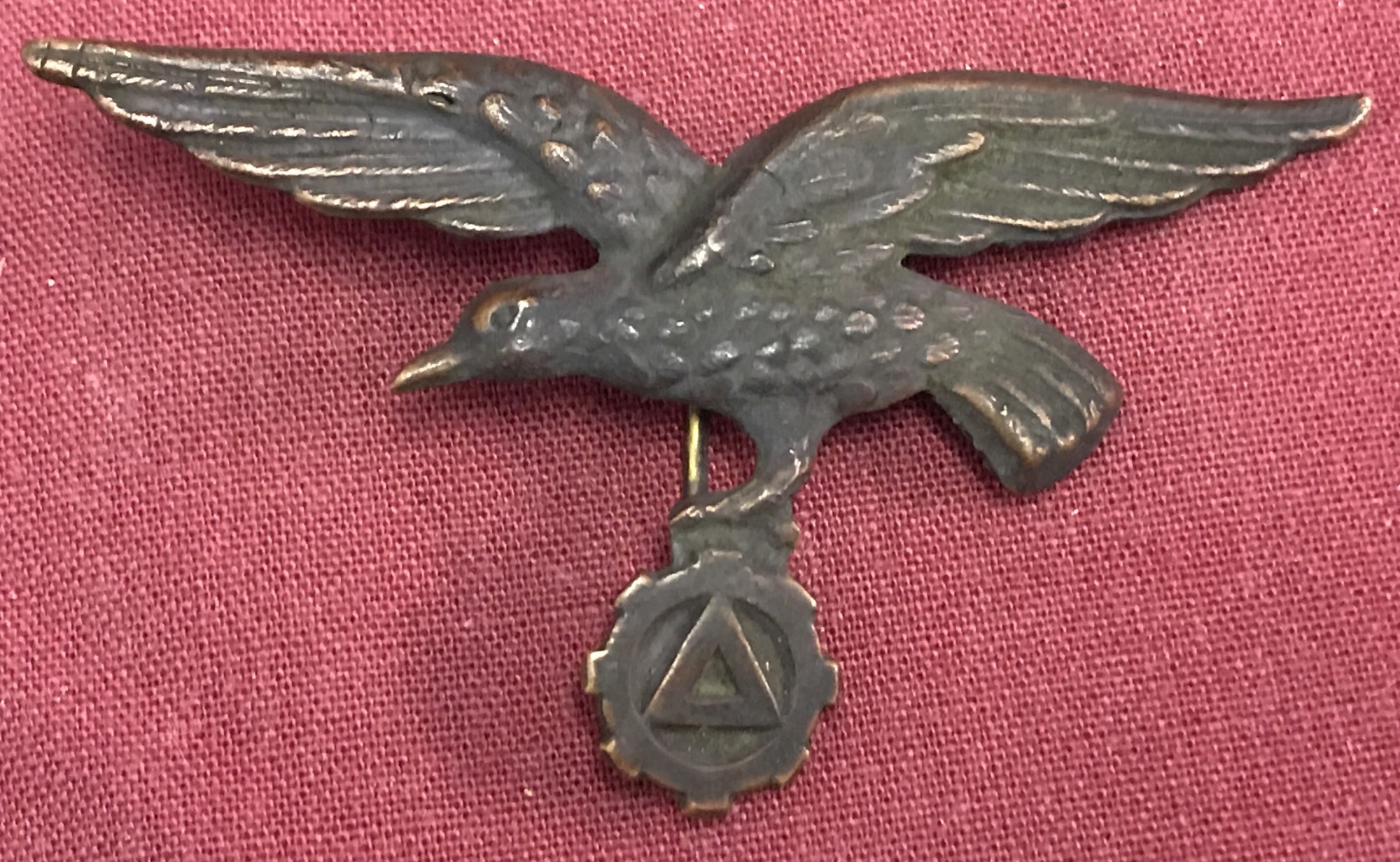 WW2 Style Three Pronged Badge. Depicting bird above cog with triangle inside.