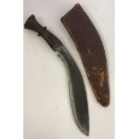 A vintage wooden handled Kukri with leather scabbard.