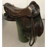 A German WWI era cavalry saddle with straps and girth, dated 1918.