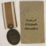 WW2 Style German West Wall Medal with gold & cream ribbon and paper packet.