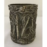 A Chinese white metal brush pot with bamboo design.