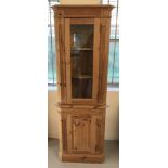 A modern pine, glass topped corner display cabinet.