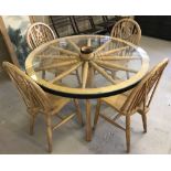 A vintage light wood, circular, glass topped, dining table made from a cart wheel.