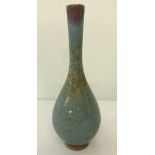 A slim necked mottled green glaze bud vase.