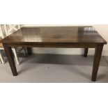 A modern polished dark oak coloured dining table.