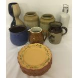 A collection of mixed stoneware items to include jars, jugs and plates.