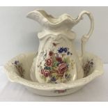 A large modern ceramic jug and bowl with basket of flowers printed detail.