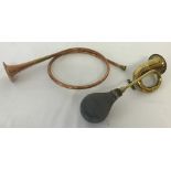 A vintage brass car horn together with a decorative copper hunting horn.