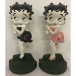 2 painted cast iron Betty Boop doorstops; one in black and white, the other in pink.