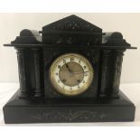 A vintage black slate and marble mantle clock with column detail to front, shaped top & gilt detail.