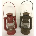2 vintage hurricane lamps with clear glass shades, one painted red.