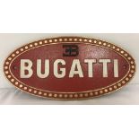 An oval shaped, painted cast iron, Bugatti wall plaque.