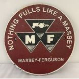 A painted cast iron, circular shaped Massey-Ferguson wall plaque.