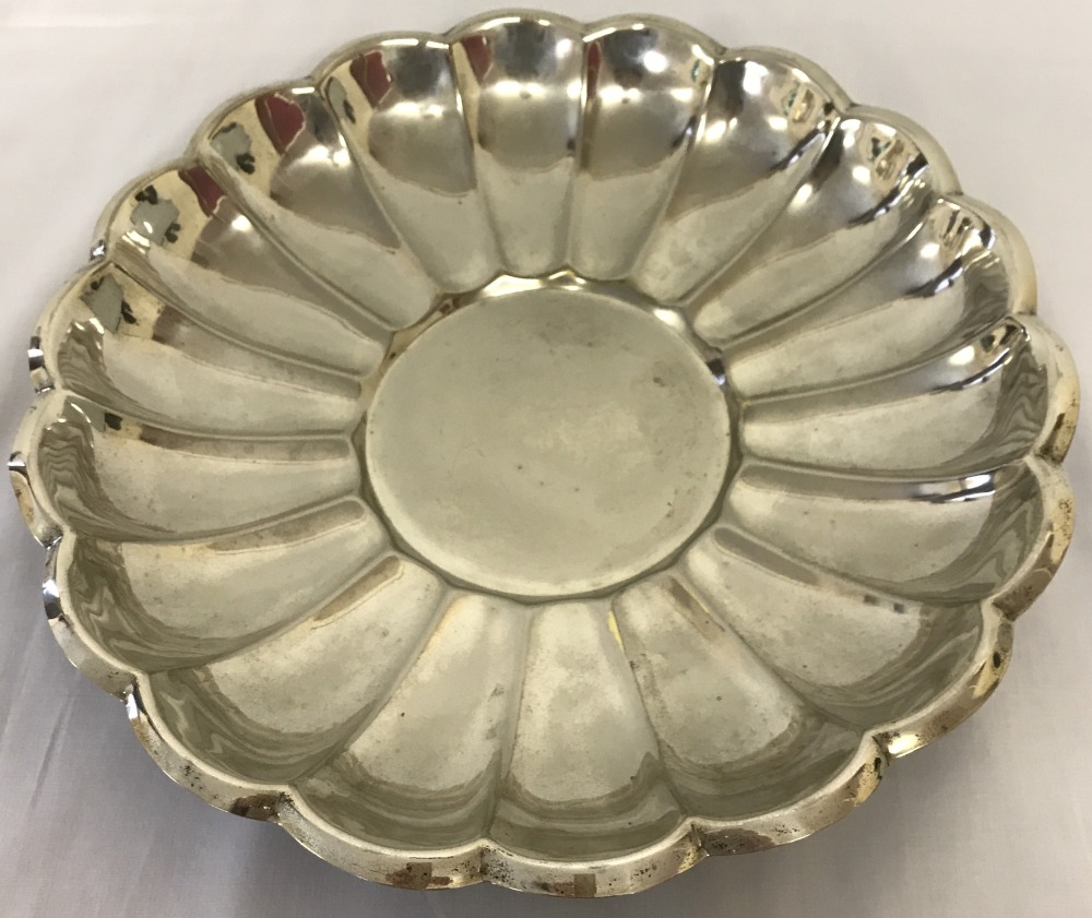 A vintage silver plated dish with scalloped rim and circular centre.