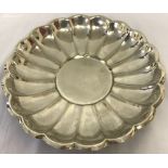 A vintage silver plated dish with scalloped rim and circular centre.