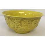 A Chinese porcelain bowl with yellow glaze and dragon detail to outer bowl.
