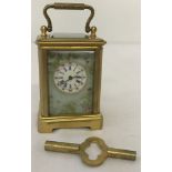 A miniature brass carriage clock with hand painted ceramic panels and bevel edged glass.