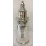 A large silver plated cocktail shaker in the shape of a lighthouse.