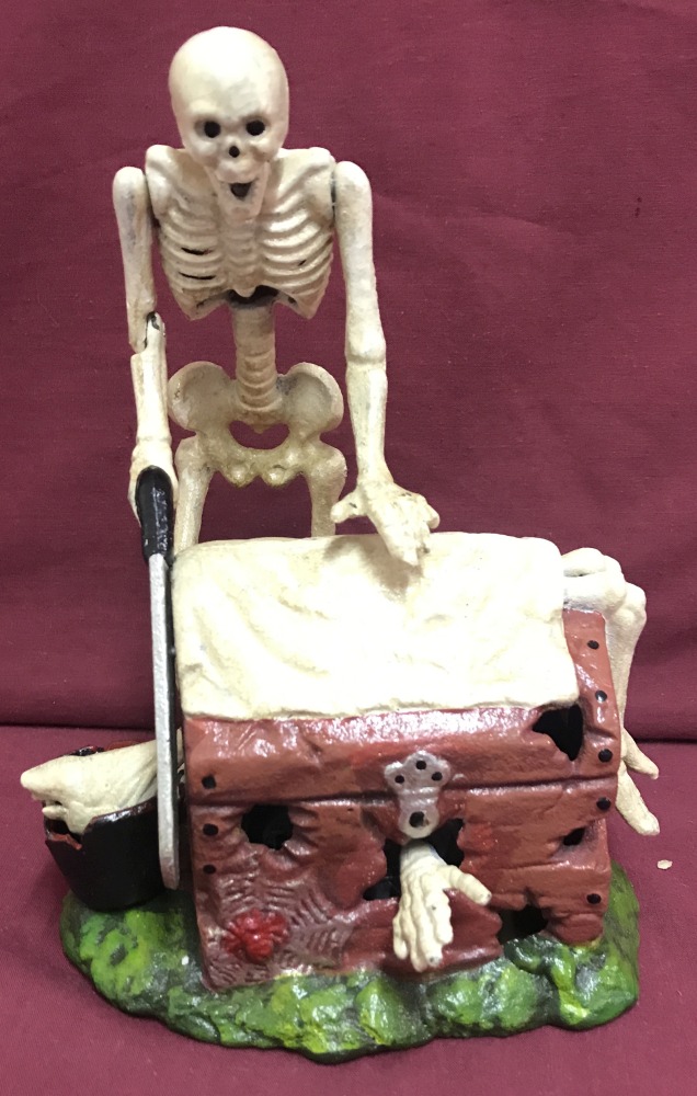 A painted cast iron money box of a skeleton cutter, with moving parts.