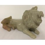 A carved soapstone laying lion figurine.