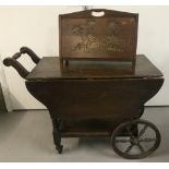 An oak coloured drop-leaf trolley and magazine rack.