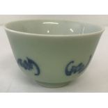 An Oriental porcelain tea bowl with green glazed outer bowl and bat design.