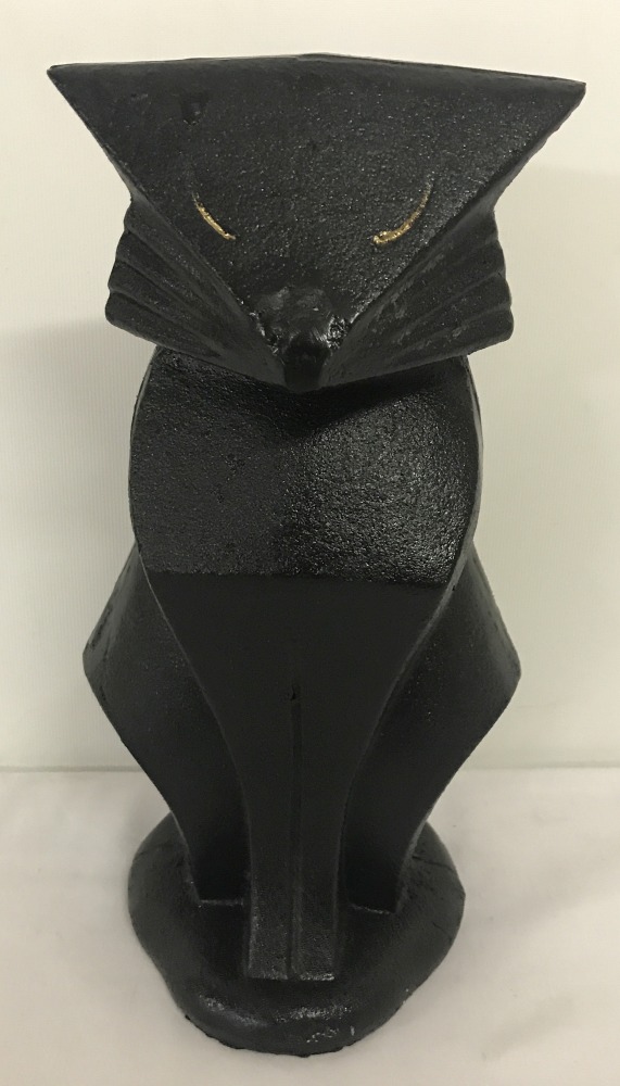 A heavy cast iron door stop in the shape of an Art Deco style cat.