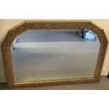 A large modern gilt framed over mantle mirror with bevel edged glass and shaped top.