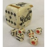 A small carved bone dice shaker with 6 miniature dice.