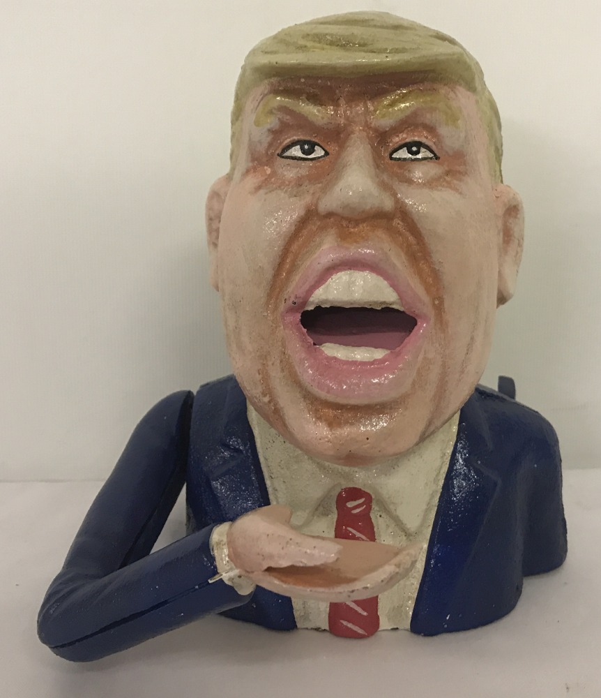 A cast iron novelty money bank in the shape of Donald Trump, with moving arm action.