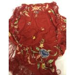 A vintage floral embroidered red shawl/scarf with fringed ends.